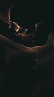 Vertical video - dark abstract motion background animation with flowing golden light and morphing organic blobs.