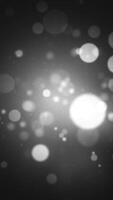 Vertical video - abstract grayscale bokeh sphere particles background with added grain. Looping, full HD motion animation.