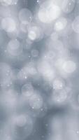 Vertical video - silver bokeh spheres background animation with shiny glittering white stars. This elegant Christmas background is full HD and a seamless loop.