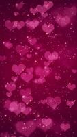 vertical vídeo - linda rosado corazones, brillante estrellas y brillante reluciente partículas en oscuro rojo degradado antecedentes. esta brillante romántico San Valentín día antecedentes es lleno hd y un sin costura bucle. video