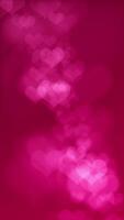 Vertical video - defocused pink bokeh hearts on dark red gradient background. This abstract romantic Valentine's Day animation is full HD and a seamless loop.