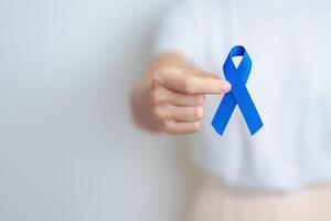 March Colorectal Cancer Awareness month, doctor with dark Blue Ribbon for supporting people living and illness. Healthcare, hope and World cancer day concept photo