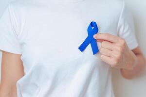 March Colorectal Cancer Awareness month, doctor with dark Blue Ribbon for supporting people living and illness. Healthcare, hope and World cancer day concept photo