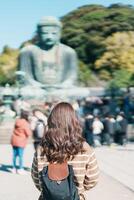 mujer turista visitando en kamakura, kanagawa, Japón. contento viajero Turismo el genial Buda estatua. punto de referencia y popular para turistas atracción cerca tokio viaje y vacaciones concepto foto