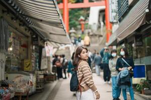 mujer turista visitando en enoshima isla, fujisawa, kanagawa, Japón. contento viajero Turismo enoshima santuario. punto de referencia y popular para turistas atracción cerca tokio viaje y vacaciones concepto foto