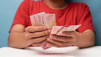 a man counts Indonesian rupiah money photo