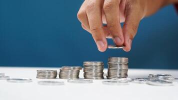 Man puts money coins stack growing business. concept of saving coins photo