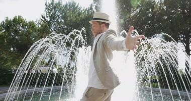 contento giovane uomo danza nel acqua Fontana nel estate tempo video