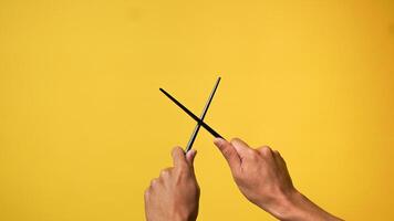 Man's hand pointing finger at camera on yellow background photo