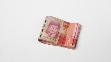 a wad of Indonesian rupiah banknotes tied with rubber photo