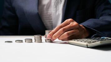 businessman puts money coins stack growing business. coin saving concept photo