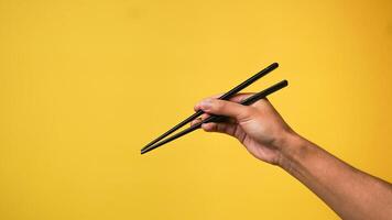 Man's hand pointing finger at camera on yellow background photo