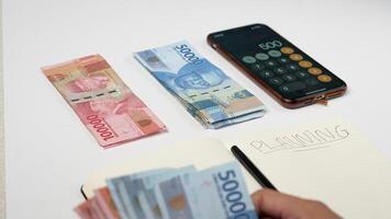 a man is counting Indonesian rupiah banknotes. financial management concept photo