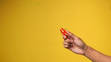 Men's hands holding clothespins on a yellow orange background photo