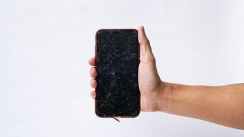 Man holding smartphone with broken touchscreen display on white background photo