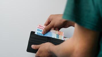 Hand takes out 50,000 and 100,000 bills from wallet. concept of paying and saving photo