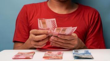 a man counts Indonesian rupiah money. financial management concept photo