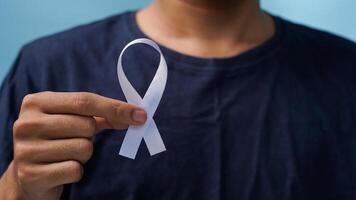 man holding a white ribbon in his hand supports world awareness day photo