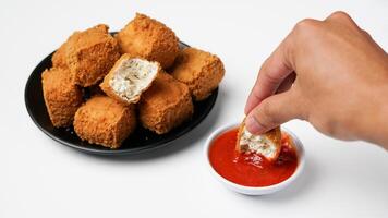 Fried tofu on a black plate with three sauces of mayonnaise, chili and sweet soy sauce on a white background photo