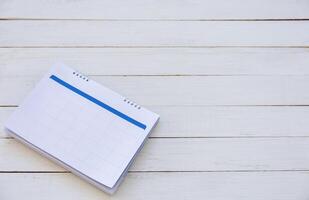 Calendar on white wood texture backgrounds with copy space for your concepts, wooden table top view photo