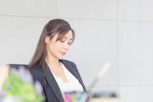 retrato de joven negocio mujer gerente trabajando a el oficina, sonriente asiático mujer trabajando en un reunión habitación foto