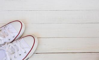 Flat lay top view of sneakers on white wooden background with copy space photo