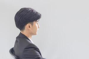 retrato de joven asiático negocio hombre con gris antecedentes foto