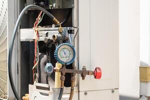 Modern air conditioning with pressure gauge check leakage system, Air Conditioning Technician team checking and fixing air conditioning photo