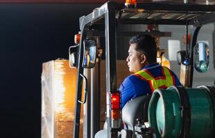 Worker driver at warehouse forklift loader works to containers box, worker man in warehouse with forklift photo
