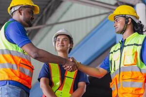 Focus on hands, Worker man shaking hands with his colleague at the industrial storage, Worker in uniform shaking hands with a foreman at factory warehouse photo