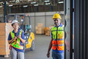 Workers team taking inventory in factory warehouse, Warehouse worker team checking containers box, Foreman workers working in warehouse talking about job photo