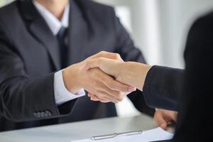 Business people shaking hands in the office. Finishing successful meeting. The businessmen and businesswoman handshake after the meeting photo