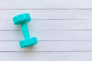 Dumbbell on white wood texture backgrounds with copy space for your concepts, wooden table top view photo