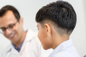 niño indio eligiendo anteojos en la tienda de óptica, niño haciendo un examen de revisión de la vista con un optometrista en una tienda de óptica, optometrista haciendo pruebas de vista para un paciente infantil en la clínica foto