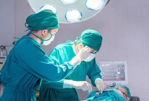 Medical team performing surgical operation in operating Room, Concentrated surgical team operating a patient photo