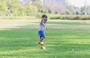 Cute little boy playing with toy in the garden, Child boy playing with little wooden toy cars outdoor photo