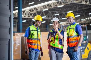 Foreman workers working in warehouse talking about job, Warehouse worker team checking containers boxes, Workers team taking inventory in factory warehouse photo