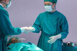 Medical team performing surgical operation in operating Room, Concentrated surgical team operating a patient photo