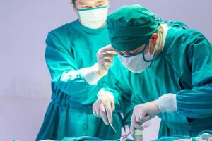 Close-up of Medical team performing surgical operation in operating Room, Concentrated surgical team operating a patient photo