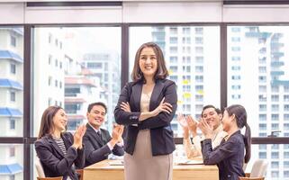 Friendly coworker congratulating businesswoman on business achievement, Group of young businesspeople clapping hands after a successful brainstorming meeting, Success and Teamwork concepts photo