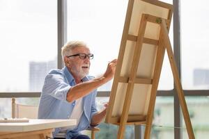 Senior man painting on canvas at home, Elderly man painting on a canvas, Happy retirement concepts photo
