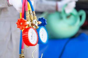 Repairman holding monitor tool to check and fixed car air conditioner system, Technician check car air conditioning system refrigerant recharge, Air Conditioning Repair photo