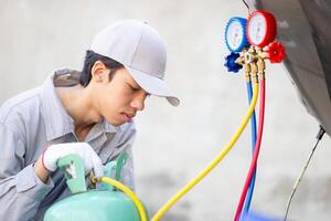 Car Air Conditioning Repair, Technician man checks car air conditioning system refrigerant recharge, Repairman with monitor tool to check and fix car air conditioner system photo