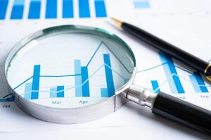 Magnifying glass on graph paper. Financial development, Banking Account, Statistics, Investment Analytic research data economy, Business concept. photo