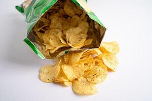 Potato chips, delicious spicy for crips, thin slice deep fried snack fast food in open bag. photo