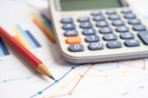 Pencil and calculator on chart or graph paper. Financial, account, statistics and business data concept. photo