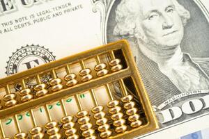 Gold abacus on USA dollar banknote money, economy finance exchange trade investment concept. photo