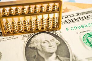 Gold abacus on USA dollar banknote money, economy finance exchange trade investment concept. photo