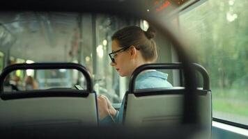 Publique transport. femme dans tram en utilisant téléphone intelligent video