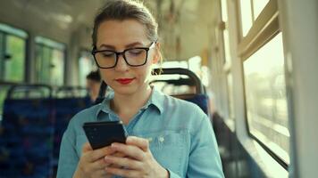 Public transport. Woman in tram using smartphone video